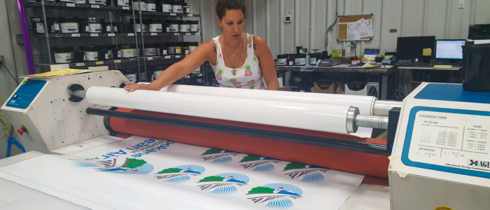designer decal employee laminating a product