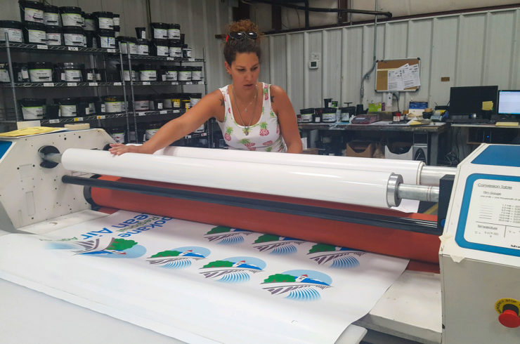 designer decal employee laminating a product